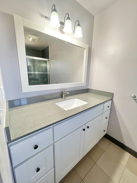 A bathroom with a sink and a mirror.