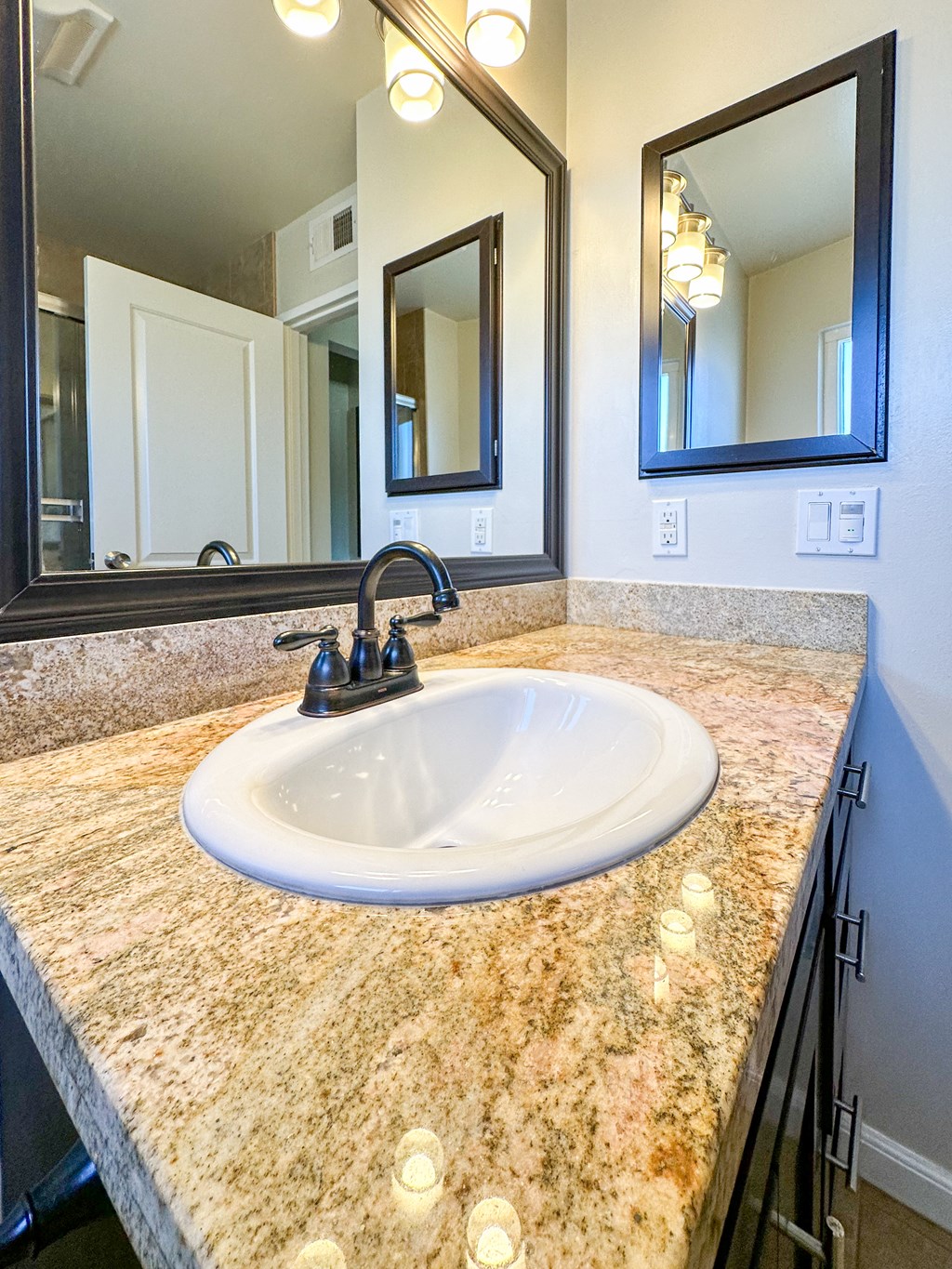 a bathroom with a sink and two mirrors