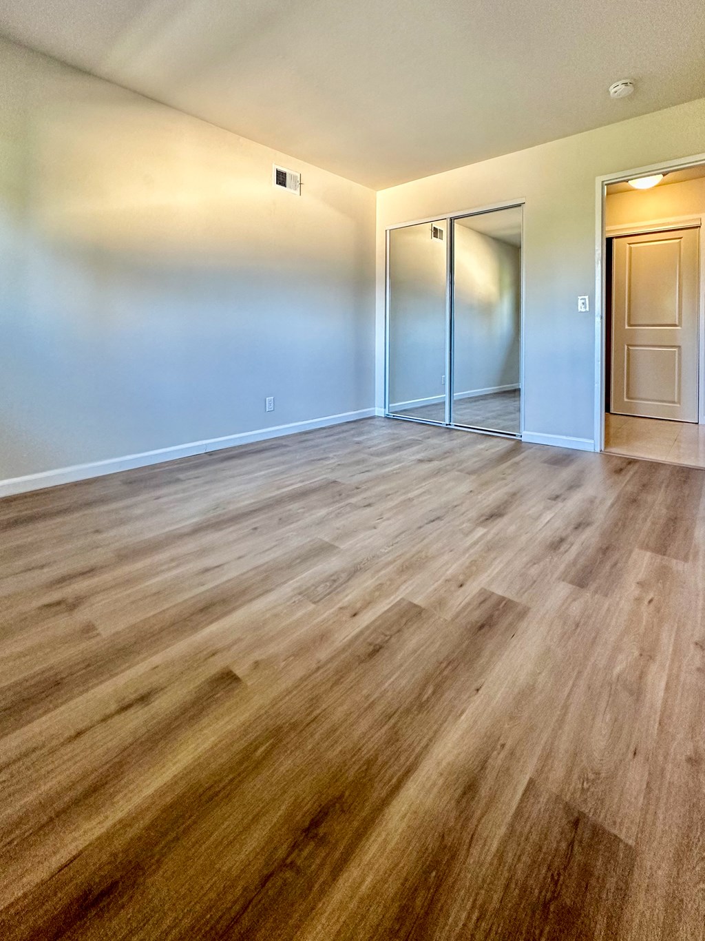 an empty living room with a hard wood floor