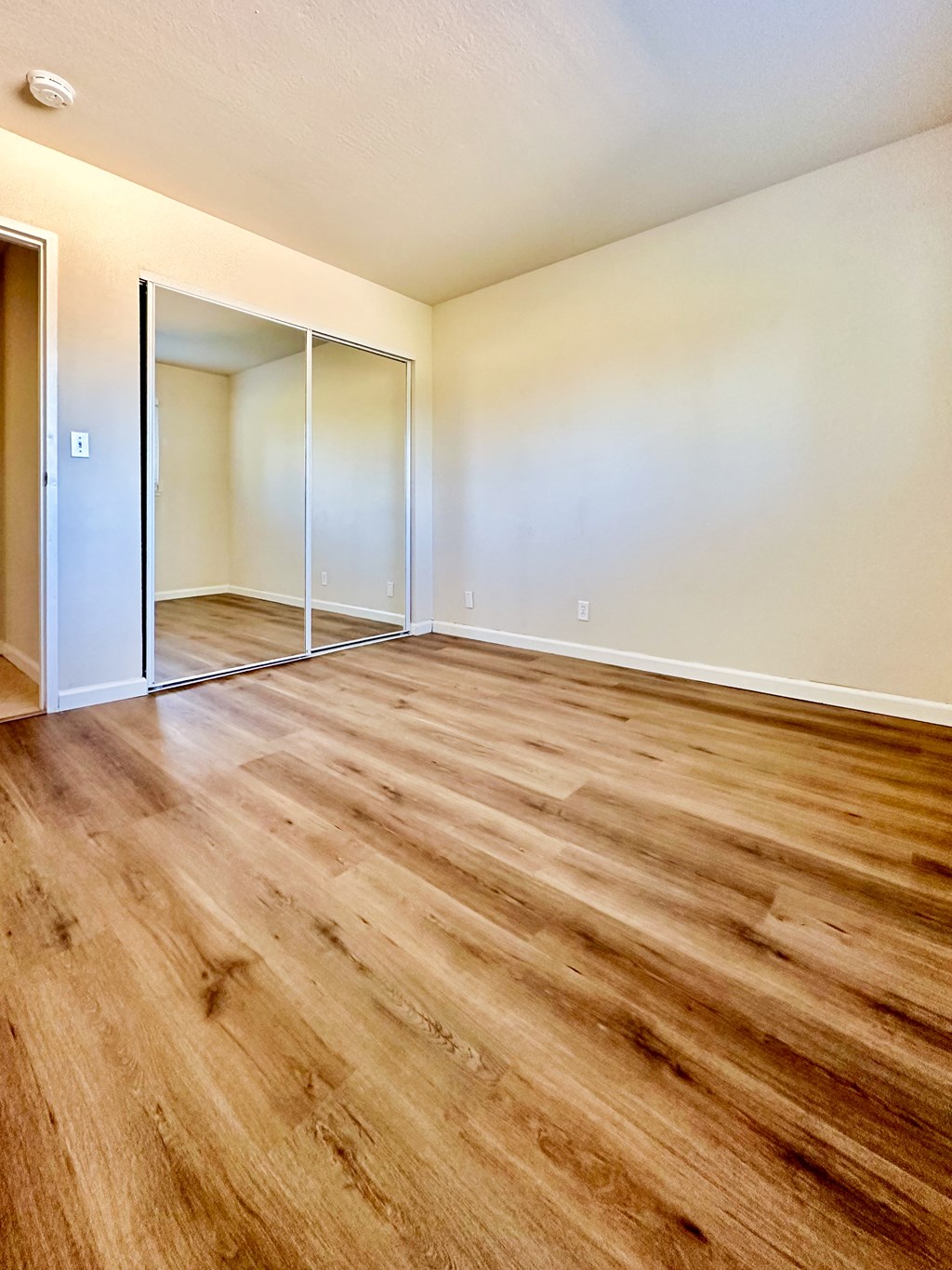 the living room of an empty apartment with wood flooring