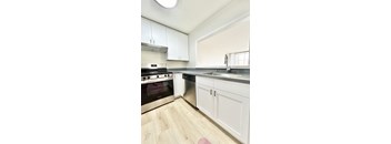 A kitchen with white cabinets and a stainless steel dishwasher.