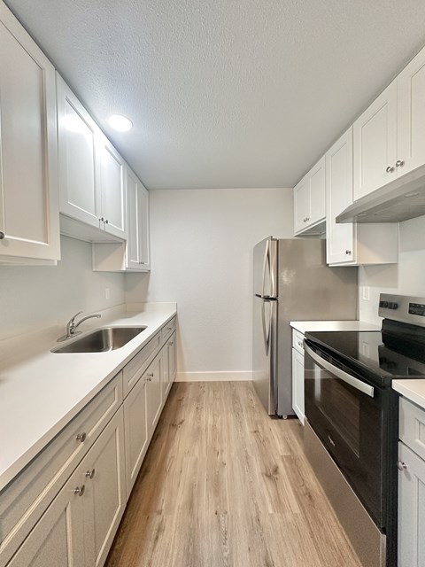 A kitchen with a stainless steel refrigerator, oven, and microwave.