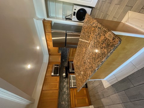 A kitchen with granite countertops and stainless steel appliances.