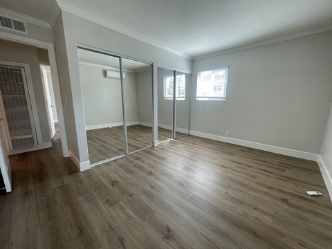 A room with a sliding glass door and wood flooring.