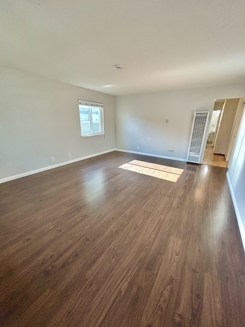 A room with wooden flooring and a window.
