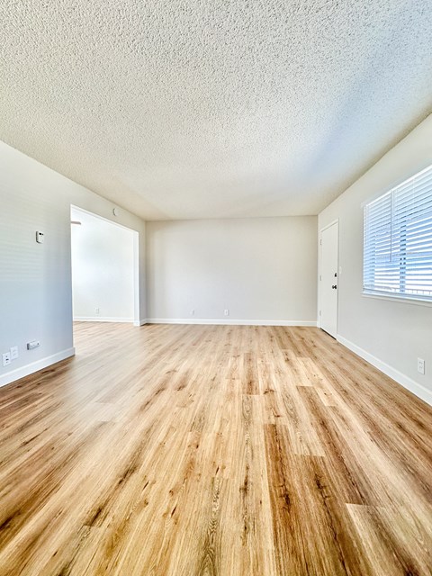 an empty living room with a hard wood floor