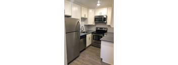 a kitchen with white cabinets and stainless steel appliances