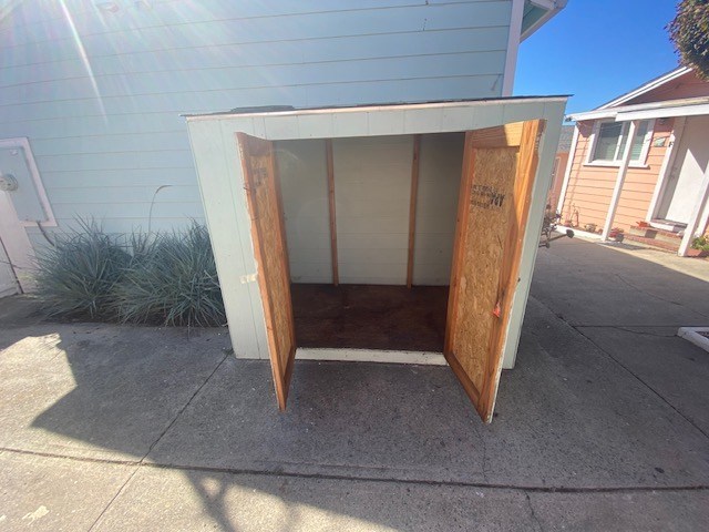 A white and brown structure is open and appears to be a shed.