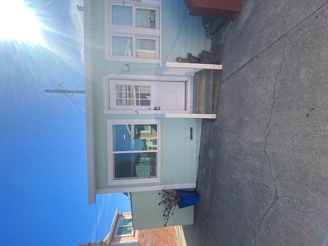 A white door is on the ground floor of a two-story house.