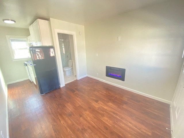 A room with a wood floor and a wall-mounted TV.