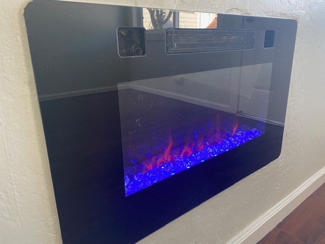 A modern fireplace with blue flames burning inside.