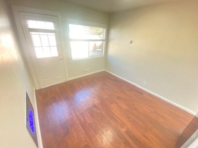 A room with a wooden floor and a window.