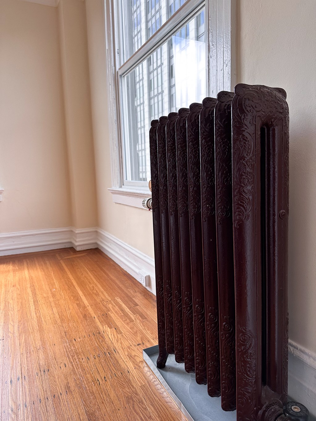 a picture of a room with a radiator in front of a window