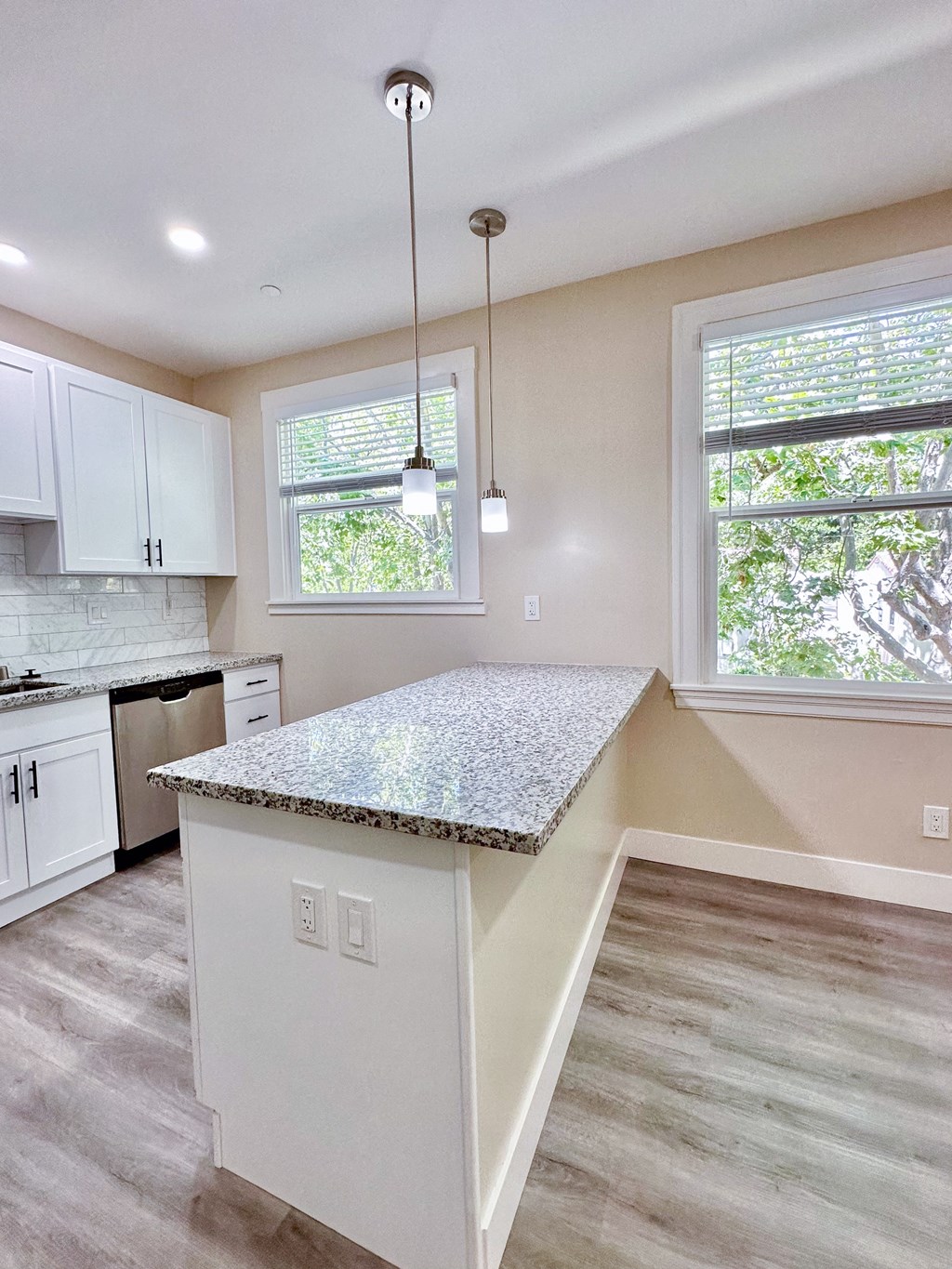 a kitchen with white cabinets and a granite counter top