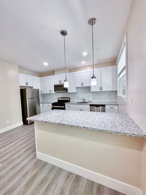 a kitchen with white cabinets and a granite counter top