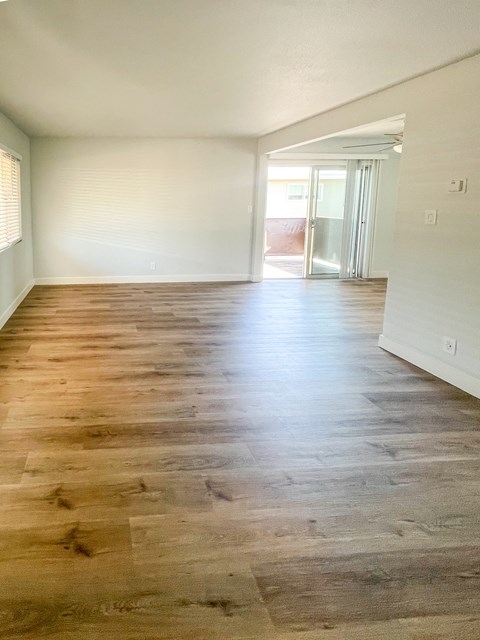 an empty living room with wood flooring in a house