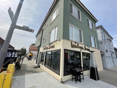 A street view of a building with a sign that reads "Singer".