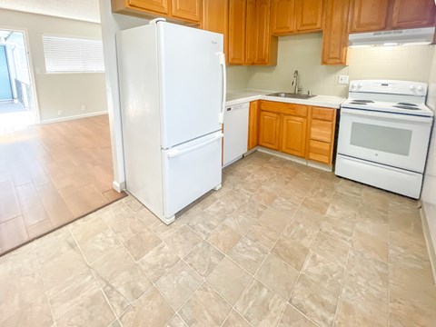 A kitchen with a white refrigerator, stove, and oven.