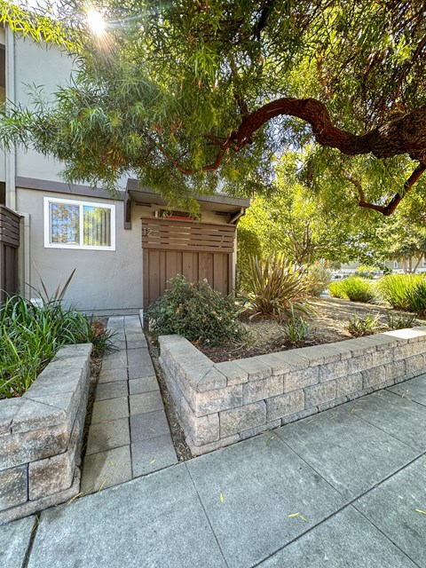 a stone retaining wall in front of a house