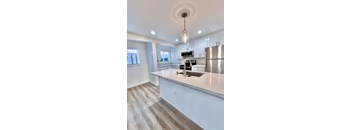 a kitchen with an island and a stainless steel refrigerator