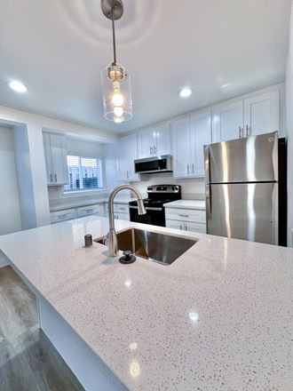 a kitchen with white cabinets and a white counter top