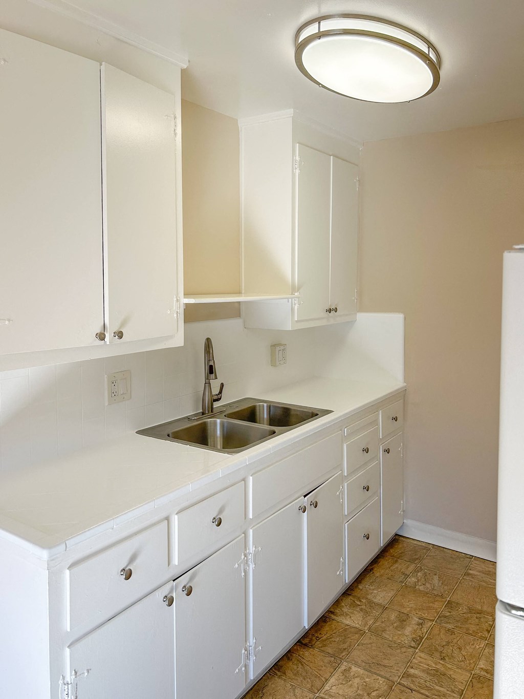 a kitchen with white cabinets and a sink