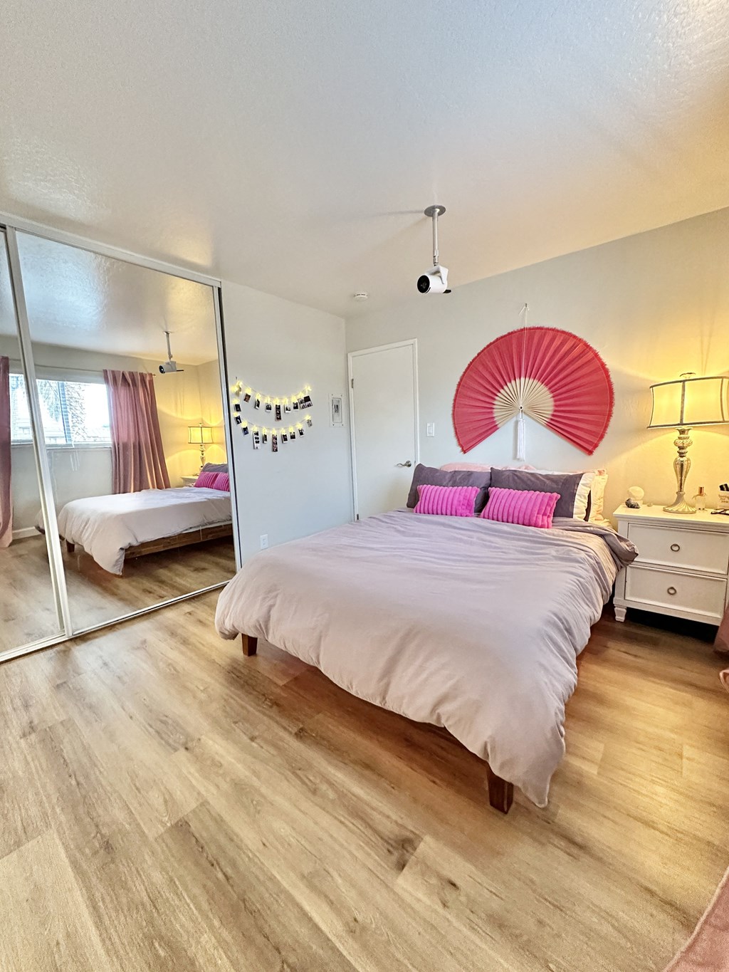 a bedroom with a large white bed and a mirror
