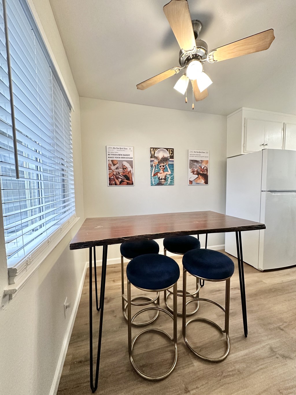 a dining area with a table and four chairs and a kitchen with a large window
