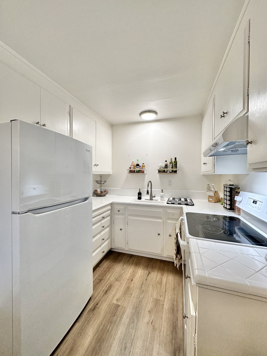 a kitchen with white cabinets and a refrigerator