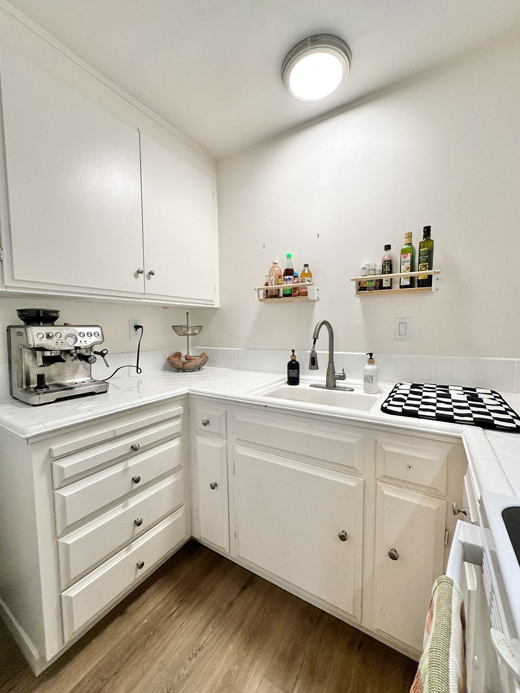 a small kitchen with white cabinets and a stove and sink