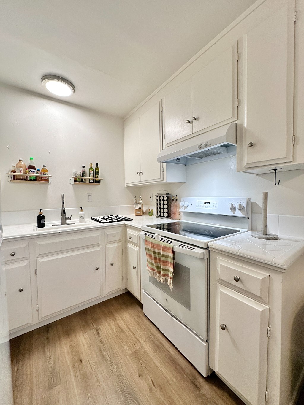a kitchen with white cabinets and a stove and a sink