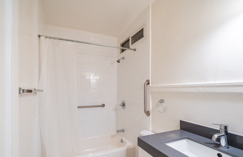 a bathroom with a sink and a shower and a bath tub