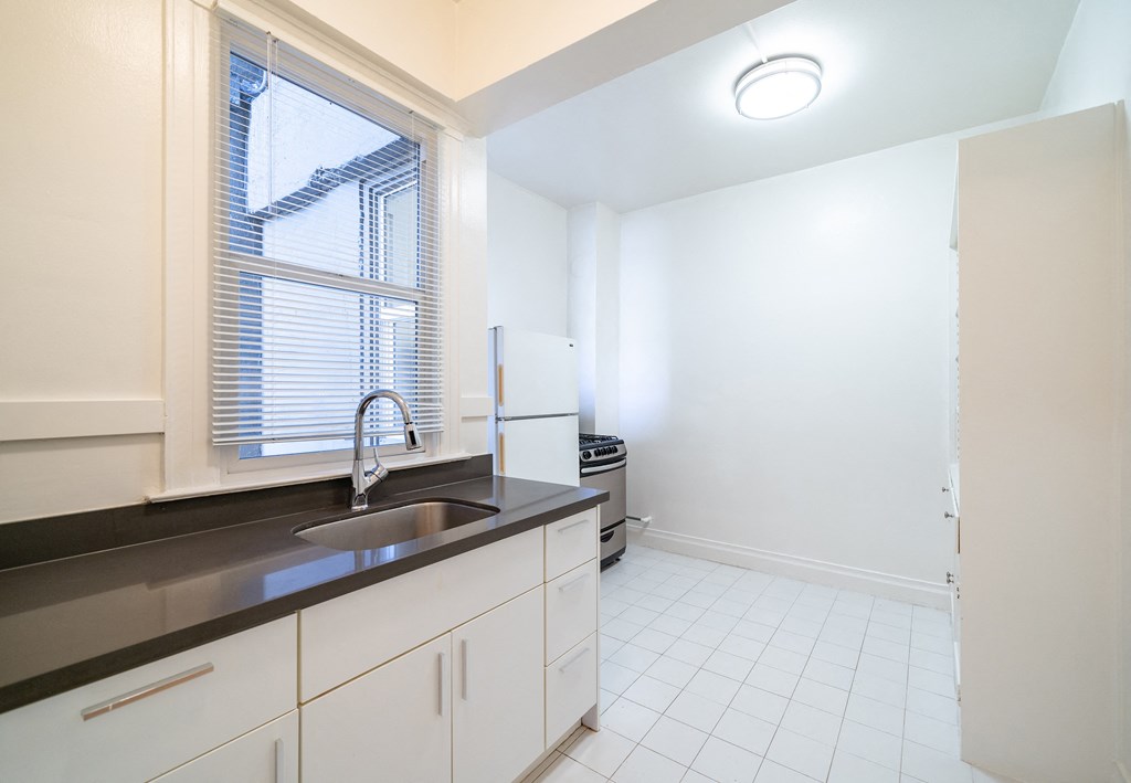 an empty kitchen with a sink and a window