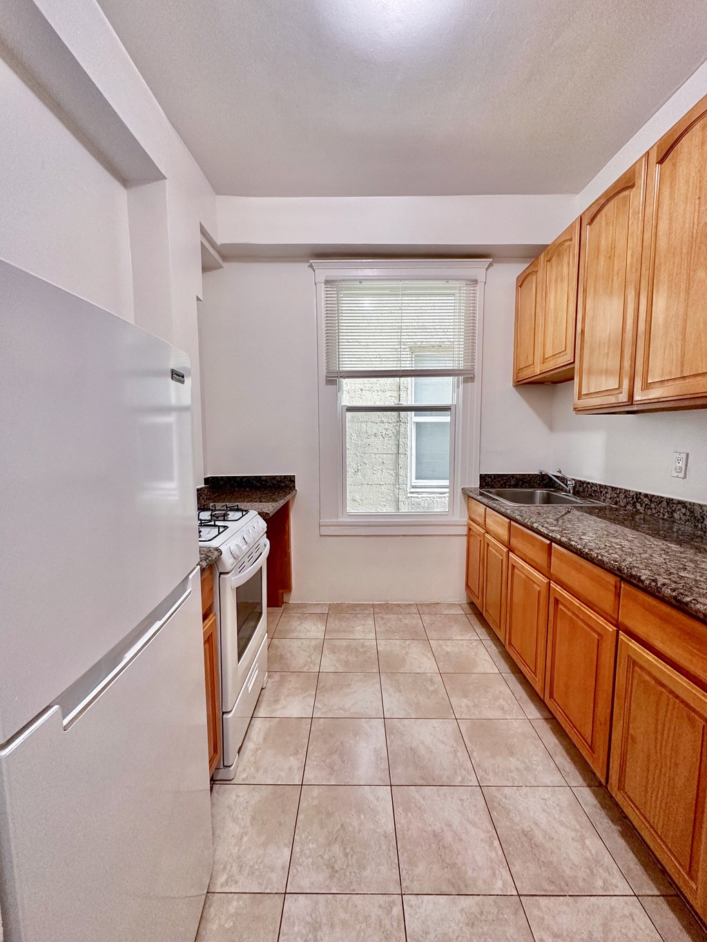 a kitchen with a white refrigerator freezer next to a stove top oven