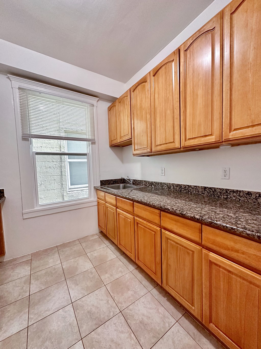 a kitchen with granite countertops and wooden cabinets