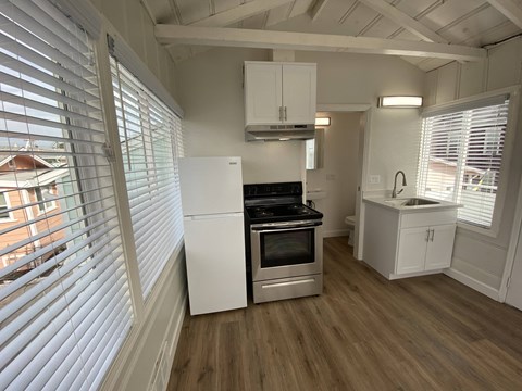 a kitchen with a stove and refrigerator in a tiny house