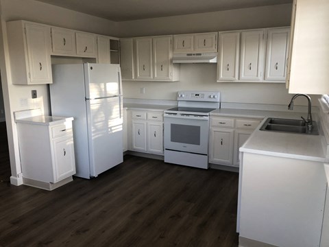 A kitchen with white appliances and cabinets.