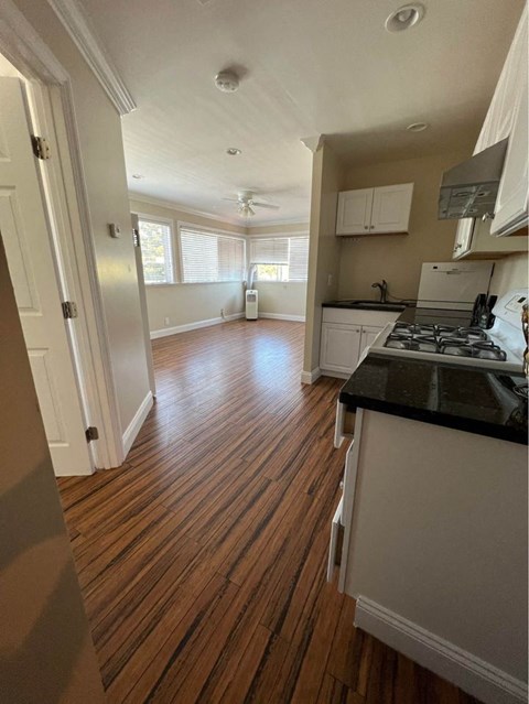 A kitchen with white cabinets and a black countertop.