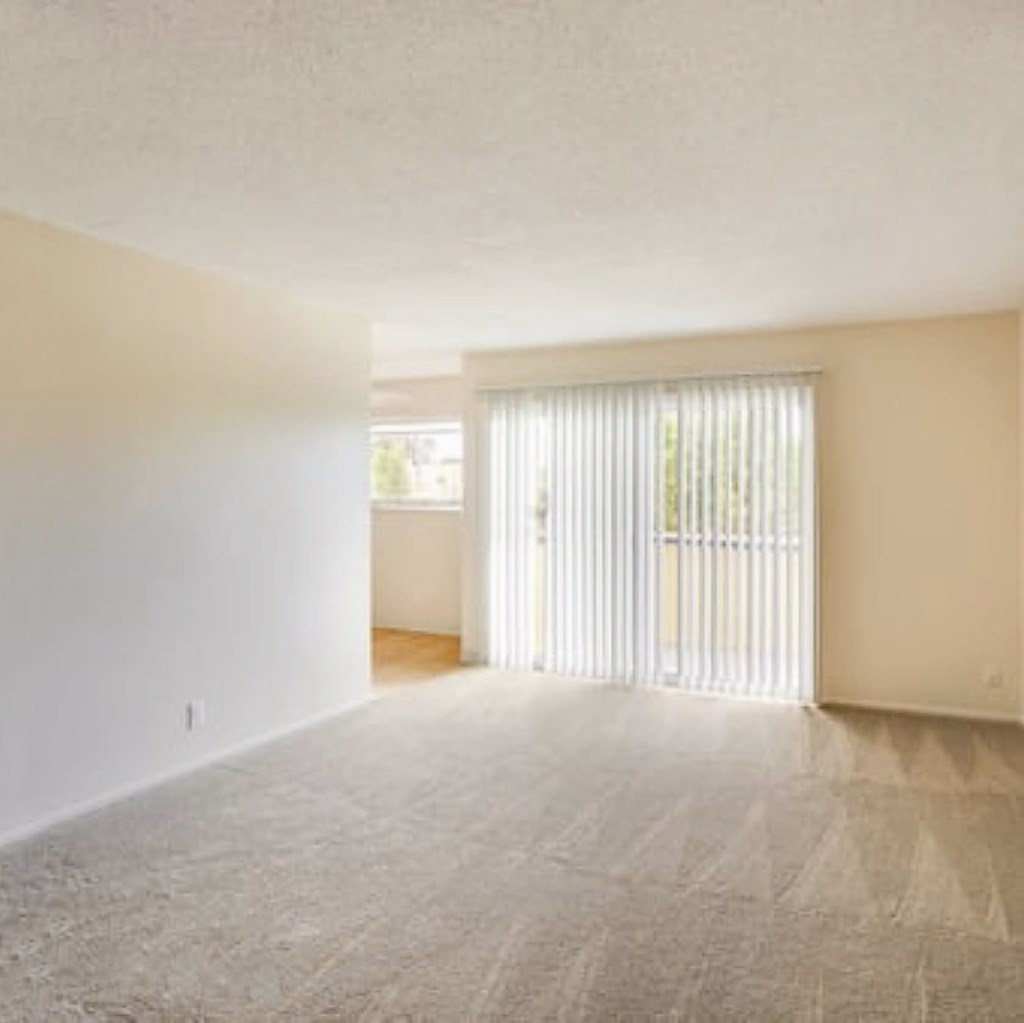 an empty living room with a sliding glass door
