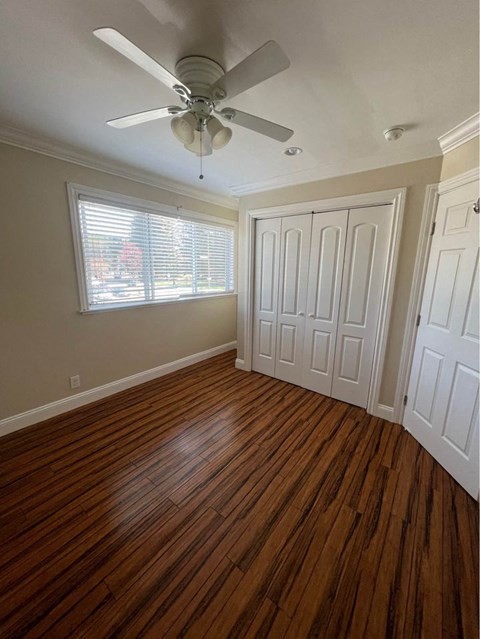 an empty room with a ceiling fan and a window