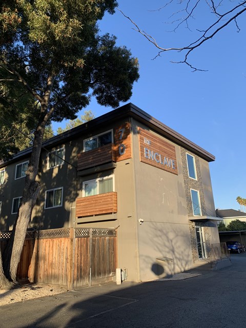 A building with a sign that says "The Enclave" on it.
