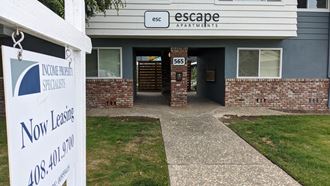 a sign in front of a building that says escape apartments