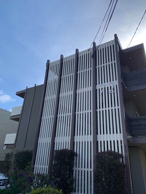 A modern building with a grey facade and a striped pattern.