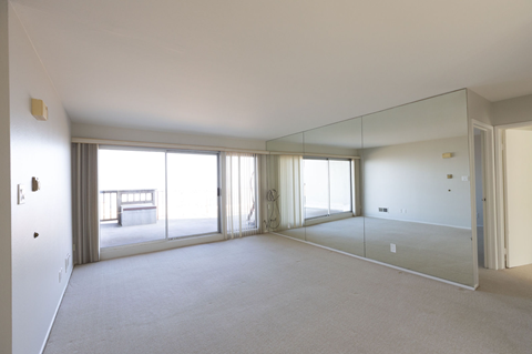 A spacious room with a glass wall and carpeted floor.