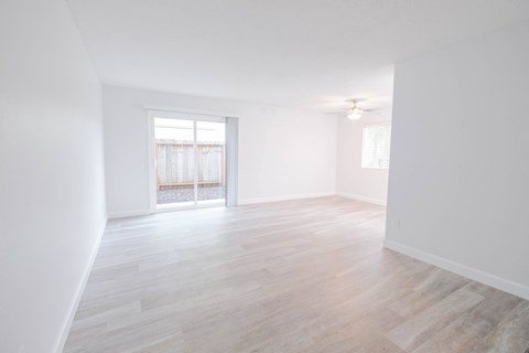 an empty living room with white walls and a sliding glass door