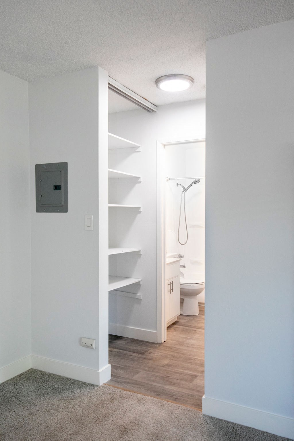 a small bathroom with a closet and a shower and a toilet