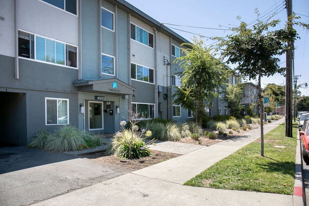 a street view of an apartment building with a sidewalk