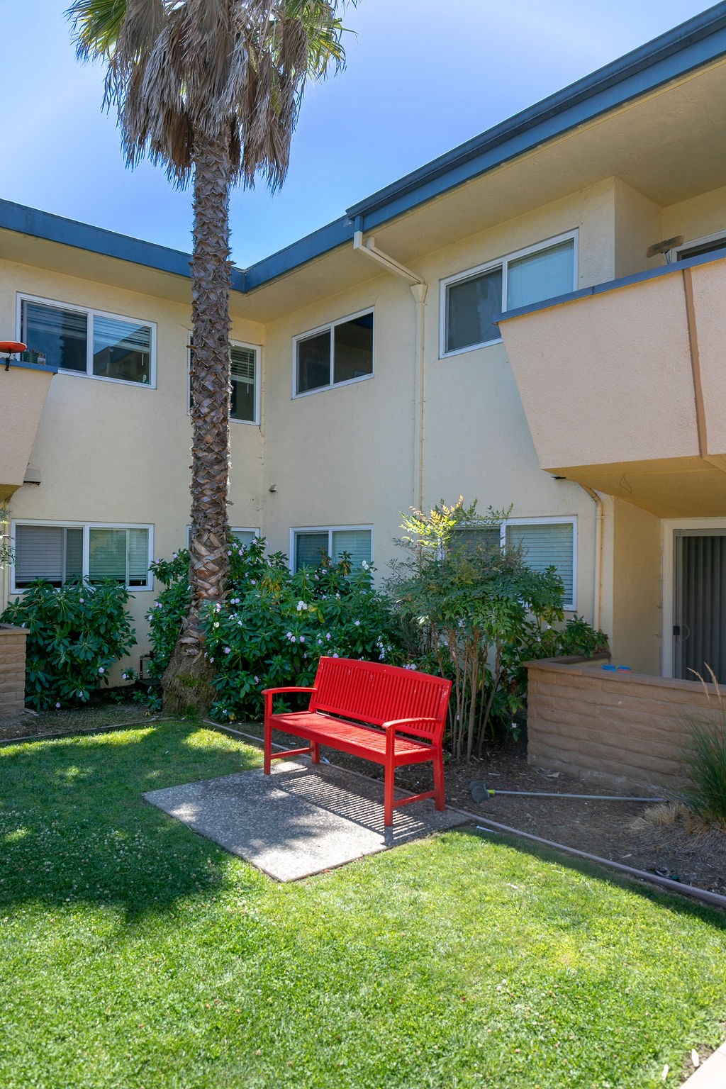 a red bench in front of an apartment building
