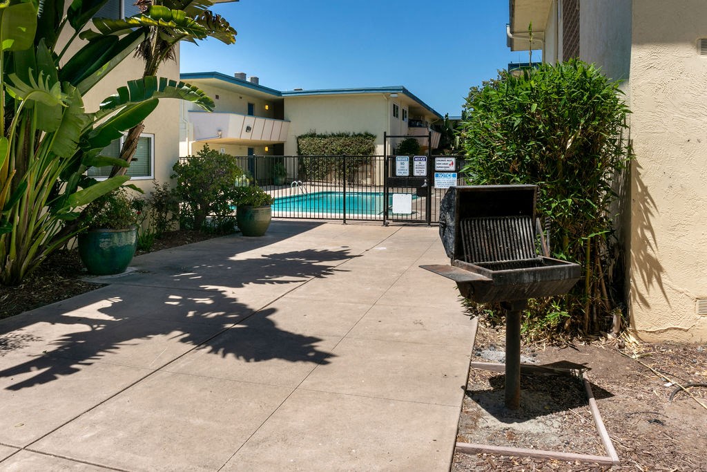 a backyard with a bench and a swimming pool