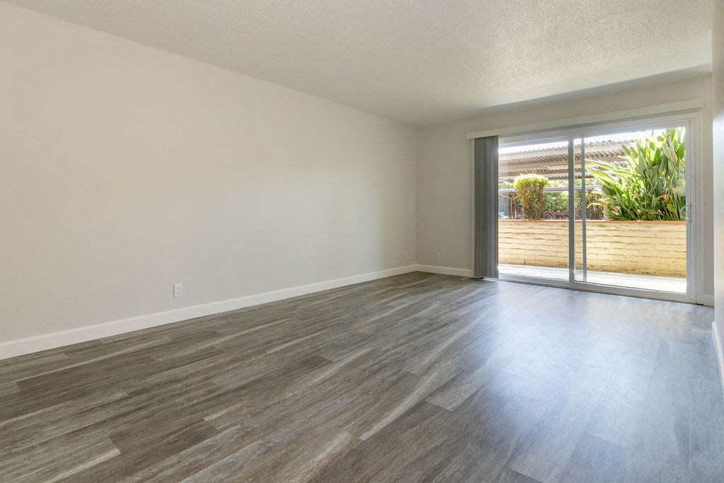 an empty living room with a sliding glass door to a patio